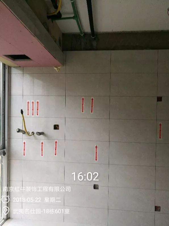 南京武夷名仕園124平米簡美風(fēng)格裝修  享受家?guī)淼臏囟?0五月份_墻磚鋪貼完成后，紅牛裝飾的工人會用專用護(hù)角條對瓷磚角保護(hù)，用標(biāo)貼標(biāo)出水管、線管走向示意。